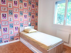 a bedroom with a bed and a wall of pictures at Chez Lulu, au pied de la Dolce Via in La Voulte-sur-Rhône