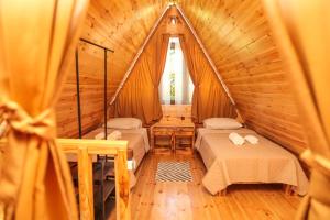 une chambre avec deux lits dans une cabane en bois dans l'établissement Cozy Cottage In Makhindjauri with Forest and Sea Views, à Makhinjauri