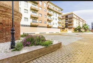 eine Straßenlaterne und Blumen vor einem Gebäude in der Unterkunft Azucarera 2 Room- HOME RENT MALAGA in Torre del Mar