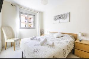 ein weißes Schlafzimmer mit einem Bett und einem Stuhl in der Unterkunft Azucarera 2 Room- HOME RENT MALAGA in Torre del Mar + 22 Fotos