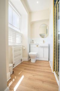 a bathroom with a toilet and a sink and a mirror at Country Retreat Sleeping 15 - Bron Menai in Newborough