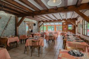 a restaurant with tables and chairs in a room at Hôtel Engilberge in Ailefroide