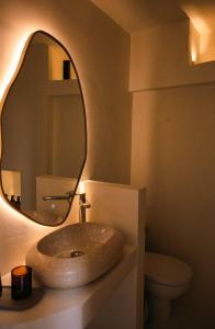 a bathroom with a stone sink and a mirror at Rosette Apartments in Pyrgi
