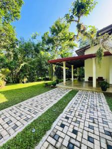a house with a stone walkway in front of a yard at Diya Villa-Boossa in Busse