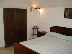 a bedroom with a bed and a wooden door at Trullo Salamina in Cisternino