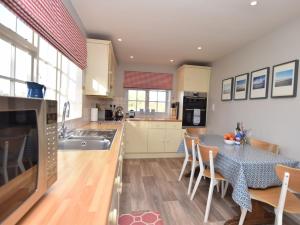 a kitchen with a table and a dining room at 3 Bed in Kettlestone KT037 in Little Snoring