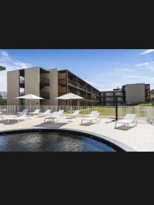 a pool with chairs and umbrellas in front of a building at Studio Pont du Gard in Remoulins