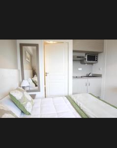 a bedroom with a large bed and a kitchen at Studio Pont du Gard in Remoulins