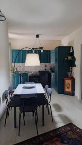 Una cocina con gabinetes verdes y una mesa y sillas. en The Peak - Mountain View Aosta - With Private Parking!, en Aosta