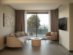 a living room with a couch and chairs and a large window at kolektif suites in Kyrenia