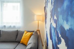 a couch with a yellow pillow in a living room at 7Seas City-Apartment Kaiserslautern - Balkon l NETFLIX l 24h Self Check-in in Kaiserslautern