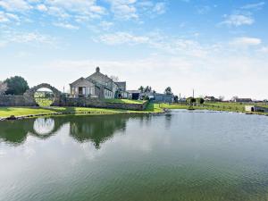 una casa grande sentada junto a un cuerpo de agua en 1 Bed in Barnard Castle 94454, en Startforth