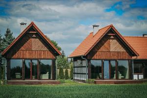 two pavilions with windows and a red roof at Drewniane Domki Całoroczne Gryszczeniówka in Wargowo