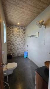 a bathroom with a toilet and a sink at Bhide farms - Avisa Nila in Alta