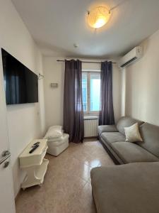 a living room with a couch and a tv at Hotel Ginevra e Residence in Cattolica