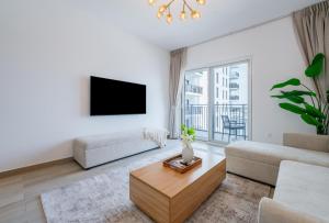 a living room with a couch and a tv at One Bedroom Apartment by Otolo Homes with Free Yas Theme Park Tickets in Abu Dhabi