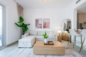 a living room with a white couch and a coffee table at One Bedroom Apartment by Otolo Homes with Free Yas Theme Park Tickets in Abu Dhabi