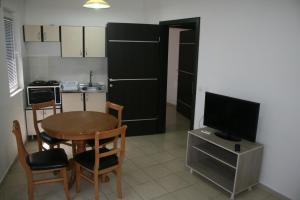 a small kitchen with a table and a television at Villa Zora in Star Dojran +13 photos