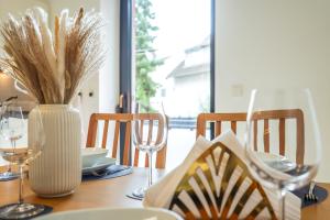 a dining room table with a vase of wheat at 7Seas City-Apartment Kaiserslautern - Balkon l NETFLIX l 24h Self Check-in in Kaiserslautern