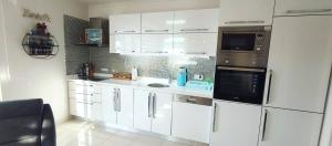 a kitchen with white cabinets and stainless steel appliances at MODA MARİNE LUXURY HOMEs in Alanya