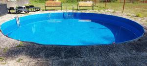 a small blue pool with chairs around it at Penzion Svojanov in Svojanov