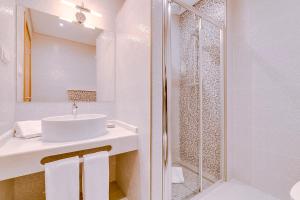 a white bathroom with a sink and a shower at Apartamentos Sol & Ria in Olhão +37 photos