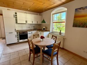 a kitchen with a table and chairs in a kitchen at Meerzeit 6 in Hohenkirchen