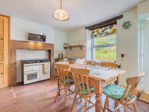 a kitchen with a table and chairs and a stove at 3 Bed in Threlkeld SZ227 in Threlkeld