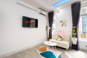 a living room with a couch and a tv at Happy house studio in Ho Chi Minh City