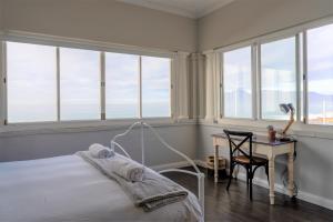 um quarto com uma cama, uma escrivaninha e janelas em The Quinmatro, with pool and garage em St James mais 29 fotografias