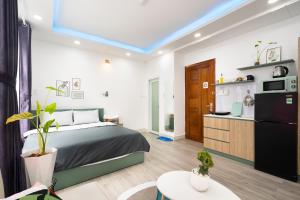 a bedroom with a large bed and a kitchen at Happy house studio in Ho Chi Minh City