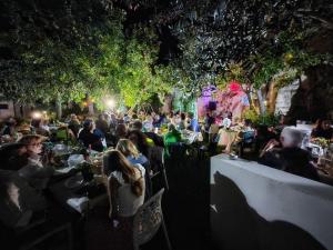 een menigte mensen die 's nachts aan tafel in een tuin zitten bij Residence IL CARRUBO in Gallipoli +84 foto's