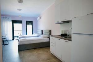 a white kitchen with a bed and a sink in it at Aren 1 in Vlorë