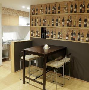 a table and some bottles of wine on a wall at Ocho Guest House in Sapporo