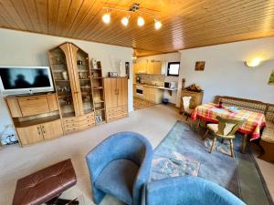 ein Wohnzimmer mit einer blauen Couch und einem Tisch in der Unterkunft Ferienwohnung Karlsruh in Warmensteinach