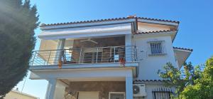 a white house with a balcony on top of it at LA Home in Aroyí
