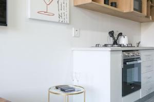 cocina con fogones y encimera con taburetes en Ballito Mirage, en Ballito