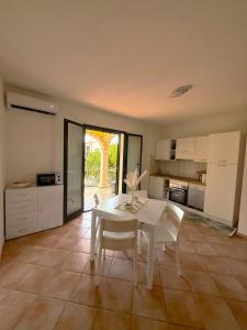 a kitchen with a white table and white chairs at Affittimoderni Valledoria - Costa Dora in Valledoria