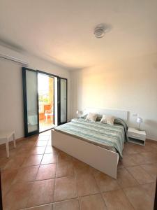 a bedroom with a large bed and a patio at Affittimoderni Valledoria - Costa Dora in Valledoria