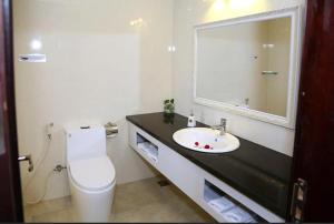 a bathroom with a toilet and a sink with a mirror at Tuyet Son Hotel (TS Ocean Hotel) in Da Nang