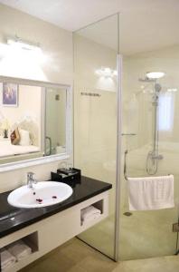 a bathroom with a sink and a glass shower at Tuyet Son Hotel (TS Ocean Hotel) in Da Nang