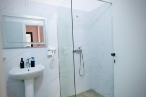 a white bathroom with a shower and a sink at Aren 1 in Vlorë