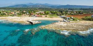 an aerial view of a beach with a boat in the water at Seaview and Sunsets - Beachside Retreats in Ayía Kiriakí