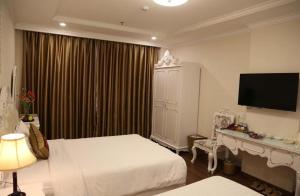 a hotel room with two beds and a television at Tuyet Son Hotel (TS Ocean Hotel) in Da Nang