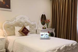 a bedroom with a white bed with a mirror at Tuyet Son Hotel (TS Ocean Hotel) in Da Nang