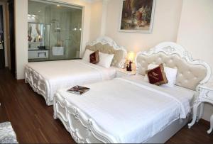 two white beds in a hotel room with at Tuyet Son Hotel (TS Ocean Hotel) in Da Nang
