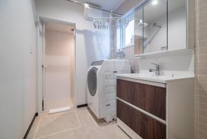 Un baño con lavadora y lavabo. en 新屋 札幌市中心 近圓山公園 挑高設計客廳 4房 2廁所 1浴室 1淋浴 最大10人 可停車, en Sapporo 36 fotos más