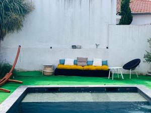 a couch sitting on a patio next to a pool at Villa des Loriots - Heated pool & walk to beaches - Anglet near Biarritz - Family friendly in Anglet