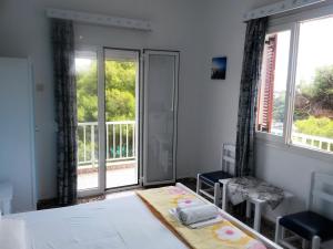 a bedroom with a bed and a large window at Magdalini in Votsi