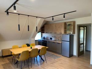 a kitchen and dining room with a table and chairs at Trio Relax Apartmanok in Kiskunmajsa